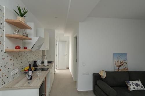 a living room with a black couch and a kitchen at Podotas Group in Kamarai