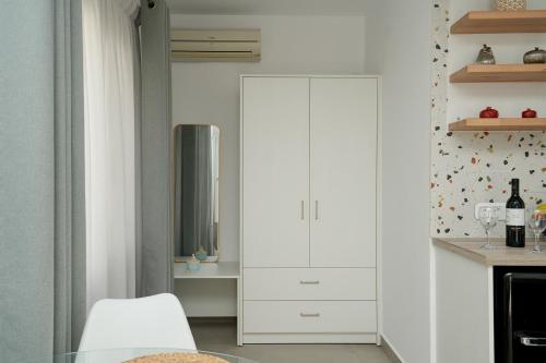 a kitchen with a tall white cabinet in a room at Podotas Group in Kamarai