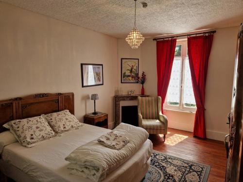 une chambre avec un lit, une chaise et une fenêtre dans l'établissement Romantic 19th century house with large garden and BBQ, à La Celle-sous-Gouzon