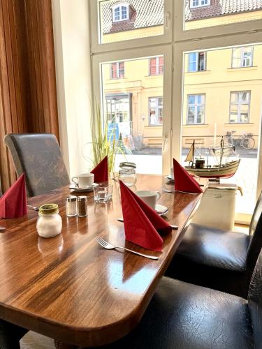 a wooden table with red paper napkins on it at Hotel Am Dom in Greifswald