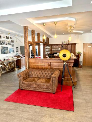 a living room with a couch on a red rug at Hotel Am Dom in Greifswald