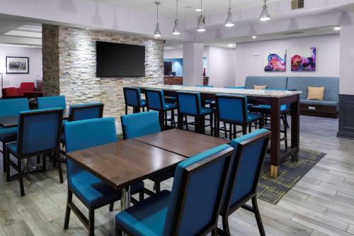 a dining room with tables and chairs and a bar at Hampton Inn by Hilton Concord/Bow in Concord