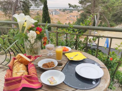 une table avec de la nourriture et un vase de fleurs dans l'établissement Bed & Diner Les Terrasses de La Palme, à Lapalme