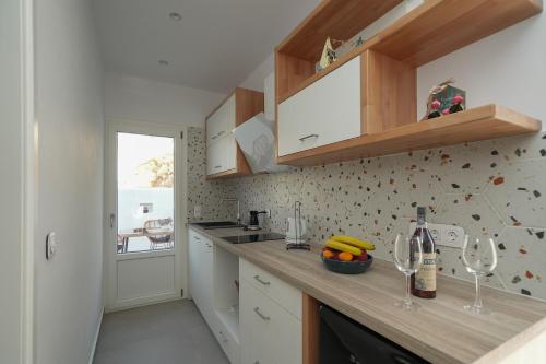 a kitchen with a counter with wine glasses on it at Podotas Group in Kamarai