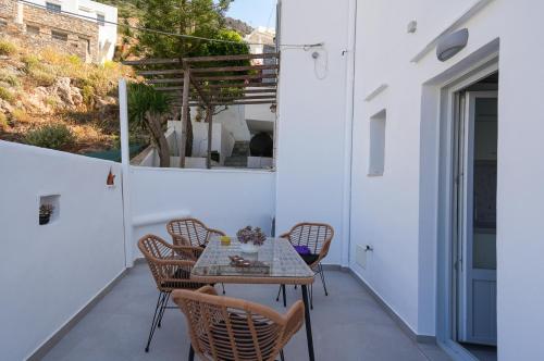 a patio with a table and chairs on a balcony at Podotas Group in Kamarai