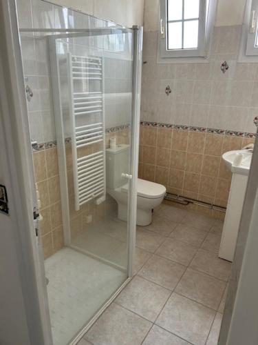 une salle de bain avec toilettes et douche en verre dans l'établissement Villa Les Volets Verts, à Blainville-sur-Mer