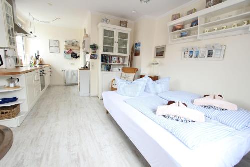 two beds in a room with a kitchen at Inselnest in Langeoog
