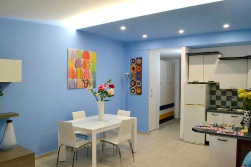 a kitchen and dining room with a white table and chairs at La Casa di Mary in Punta Secca