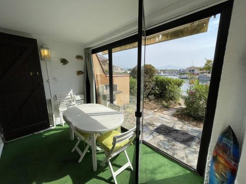 Cette chambre dispose d'une table, de chaises et d'un balcon. dans l'établissement T3 calme avec terrasse, clim et parking proche plage - FR-1-106-45, à Saint-Cyprien