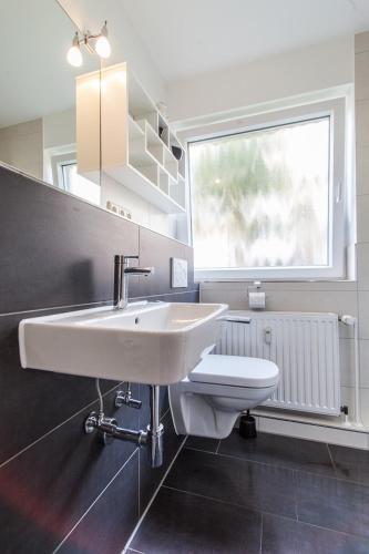 a bathroom with a white sink and a toilet at Inselschatz in Langeoog