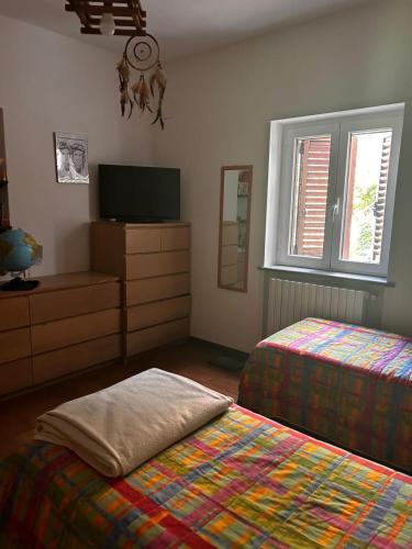 a bedroom with two beds and a flat screen tv at villa Cycas in Maratea