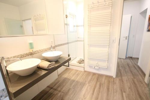 a bathroom with two sinks and a mirror at Ferienhaus Stefanie 1 in Langeoog