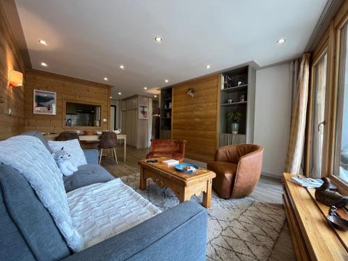 un salon avec un canapé bleu et une table dans l'établissement Appartement moderne avec balcon, WiFi et cuisine équipée - FR-1-694-168, à Val dʼIsère