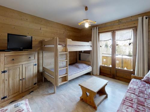 - une chambre avec 2 lits superposés et une télévision dans l'établissement Appartement cosy près des pistes avec balcon au Grand-Bornand - FR-1-467-56, au Grand-Bornand