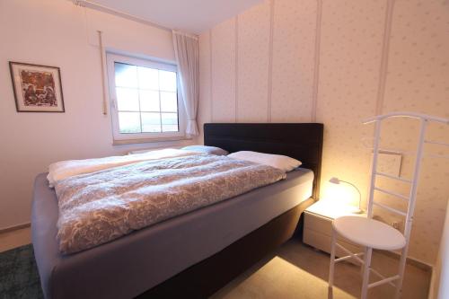 a bedroom with a bed and a ladder and a window at MeeresZeit in Langeoog