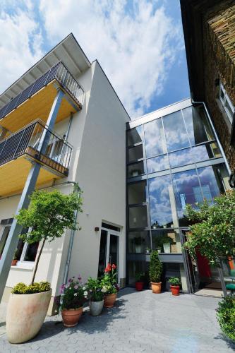a building with potted plants in front of it at Landhotel Sanct Peter in Bad Neuenahr-Ahrweiler