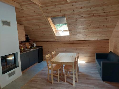 a kitchen and dining room with a wooden table and chairs at Willa Ozark in Zawóz