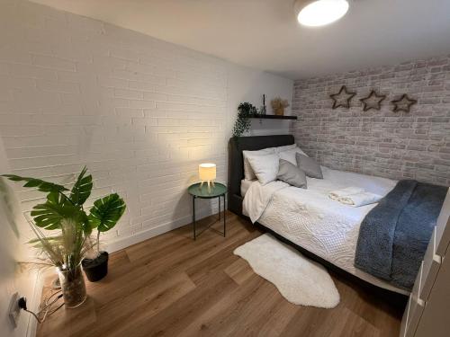 a bedroom with a bed and a brick wall at Studio for City Breaks in Balham in London