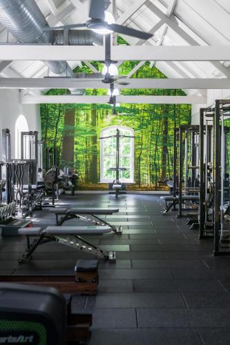 a gym with rows of exercise equipment and trees at Combe Grove Health and Wellness in Bath
