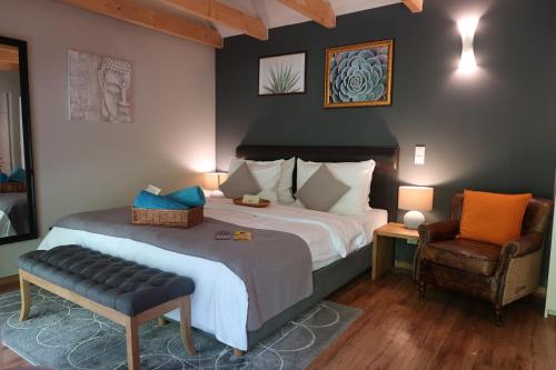 a bedroom with a large bed and a chair at Lodge Hotel Heiligendamm- digitales & rezeptionsloses Hotel in Heiligendamm