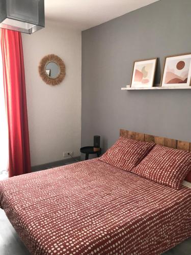 une chambre avec un lit avec une couette rouge dans l'établissement Émerveillez-vous en Ardèche, à Privas