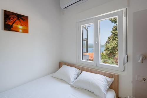 a bedroom with a bed and a window at Apartmani Mandić in Neum
