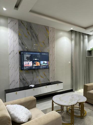 a living room with a tv on a wall at Nkunzi Beautiful Homes in Kampala