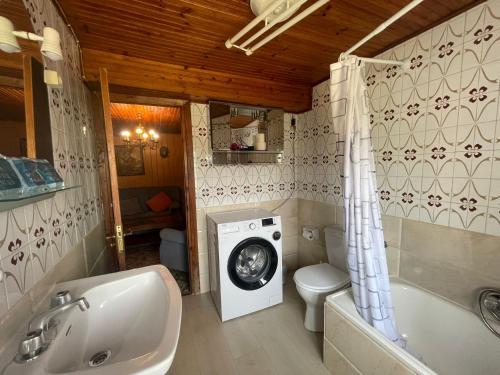 a bathroom with a washing machine and a sink at La Casina de Castiello in Castiello
