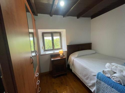 a small bedroom with a bed and a window at La Casina de Castiello in Castiello