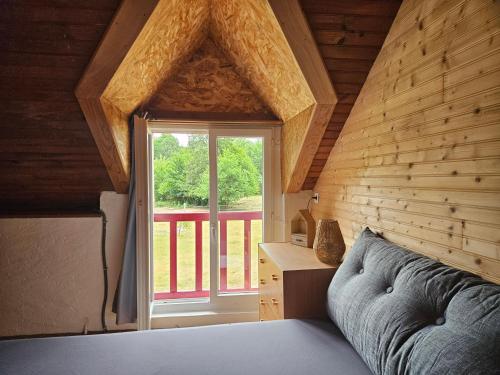a bedroom with a bed and a window in a room at Ma Petite Forêt in Clémont