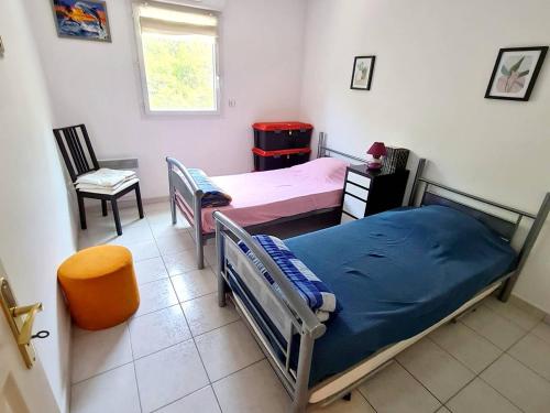 une chambre avec deux lits et une chaise et une fenêtre dans l'établissement Appartement T3 avec Terrasse et Garage - À 600m des Plages et Commerces, Résidence Sécurisée - FR-1-316-205, à Six-Fours-les-Plages