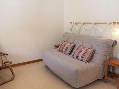 a couch with two pillows in a living room at Studio Cabine avec Coin Nuit, 6 Couchages, Centre Station, Proche Pistes et Commerces - FR-1-330B-138 in Vars