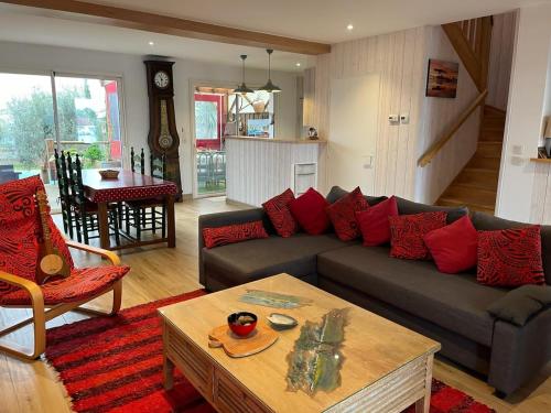 - un salon avec un canapé gris et des oreillers rouges dans l'établissement Villa 6 pers piscine vue port parking, à La Teste-de-Buch