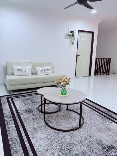 a living room with a table and a couch at Rayyan Homestay in Pasir Puteh