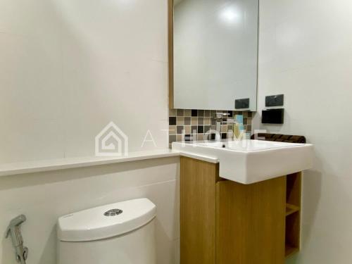a bathroom with a white sink and a toilet at The Breeze Beachside in Ban Nong Chap Tao