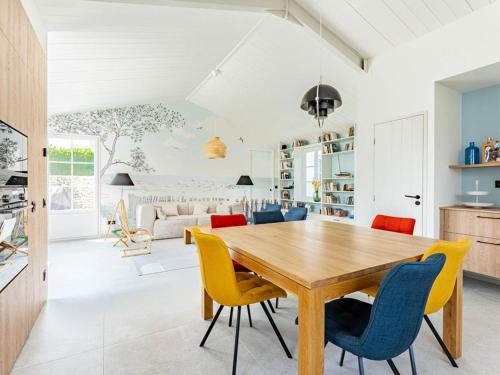 une cuisine et une salle à manger avec une table et des chaises en bois dans l'établissement Maison de vacances avec jardin verdoyant à Loix - FR-1-835-25, à Loix