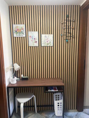 a desk with a chair next to a striped wall at Tucano studio apartment in Rho