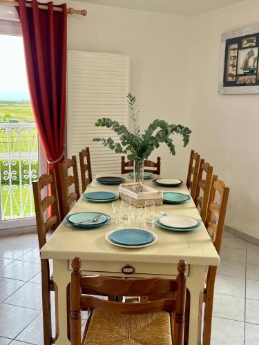 - une table à manger avec des assiettes et des verres à vin dans l'établissement Gîtes de la Mouette L'Estran 8 à 9 personnes, à Ravenoville