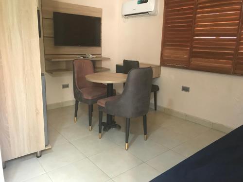 a room with a table and chairs and a television at Homegate Resort in Araromi