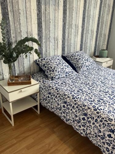 une chambre avec un lit et une table avec une plante dans l'établissement Gîtes de la Mouette L'Estran 8 à 9 personnes, à Ravenoville