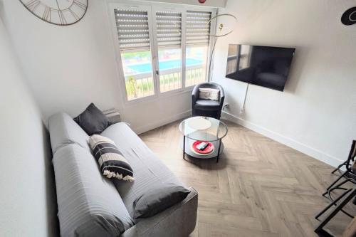 un salon avec un canapé et une télévision dans l'établissement Naturiste Cap d'Agde Port Soleil 146, au Cap d'Agde