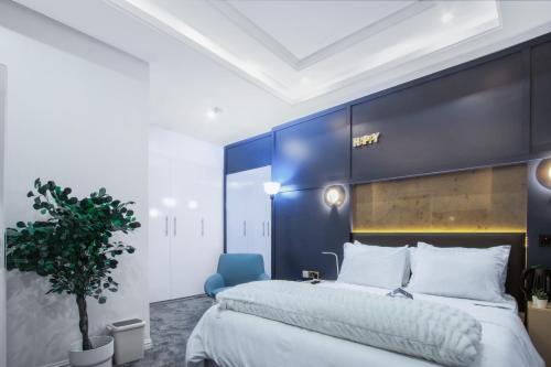 a bedroom with a large bed and a blue wall at Wallgate Apartments Limited in Jahi