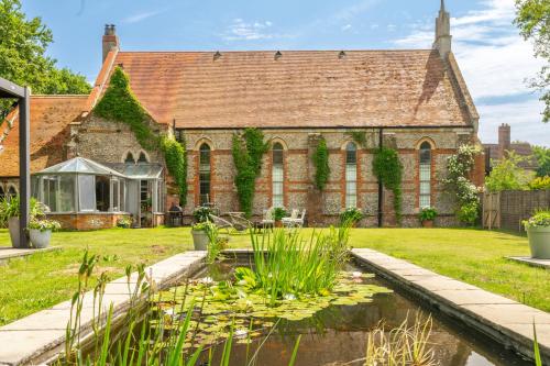 an old brick building with a pond in front of it at The Chapel in North Elmham