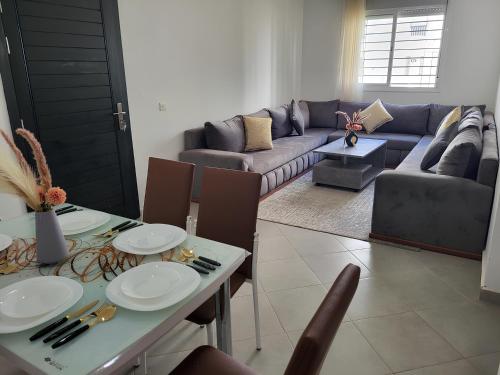 a living room with a table and a couch at Cosy Apartment Near Beach & Airport in Tangier