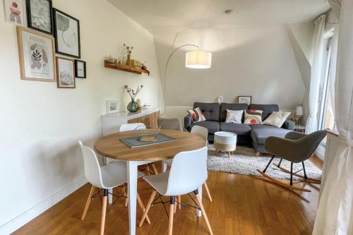 un salon avec une table et un canapé dans l'établissement T2 apartment with balcony near beach, à Houlgate