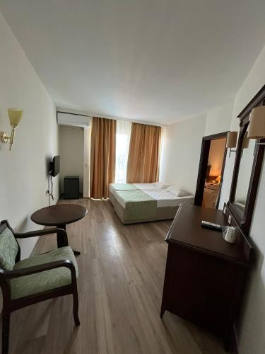 a hotel room with a bedroom with a bed and a desk at Side Palm D'or Hotel in Side