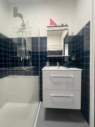 une salle de bain avec un lavabo, une douche et un miroir dans l'établissement Les Caroubiers, à Roquebrune-Cap-Martin