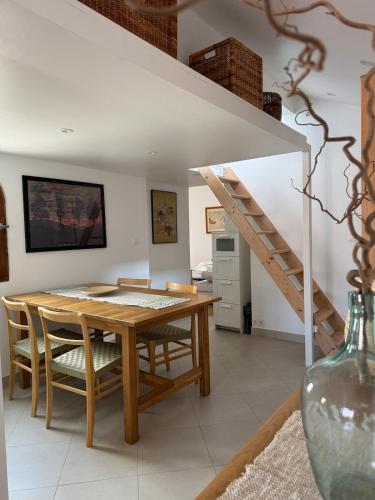 une salle à manger avec une table en bois et un escalier dans l'établissement Renovated luxury cocoon Place Masséna, à Nice