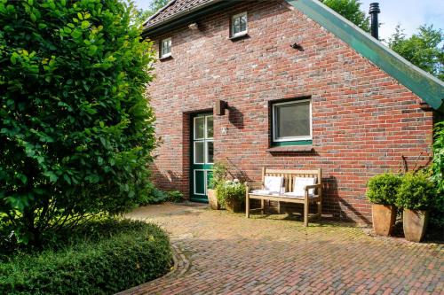 a brick house with a bench in front of it at Ferienhaus Neudorf in Varel