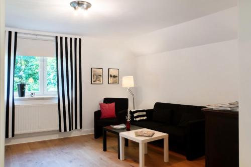a living room with a black couch and a window at Ferienhaus Neudorf in Varel